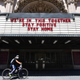 A cyclist wearing a face mask rides past the Million Dollar Theater, closed due to the coronavirus pandemic, in Los Angeles, California on May 4.